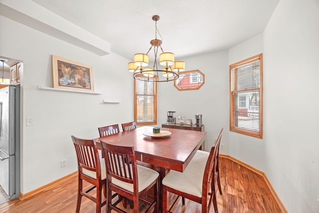 dining area featuring hardwood / wood-style floors, an inviting chandelier, and plenty of natural light