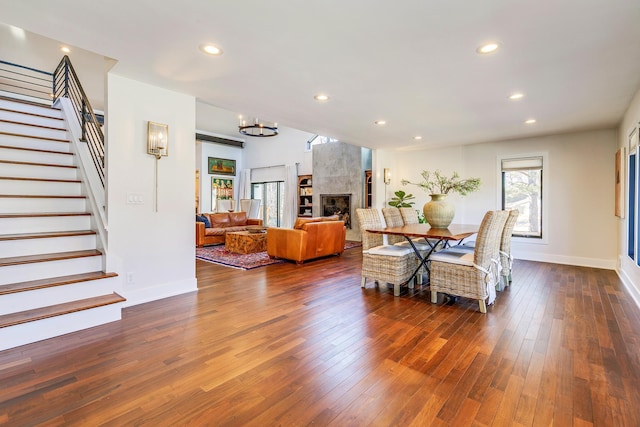 dining space featuring stairway, baseboards, recessed lighting, dark wood-type flooring, and a chandelier