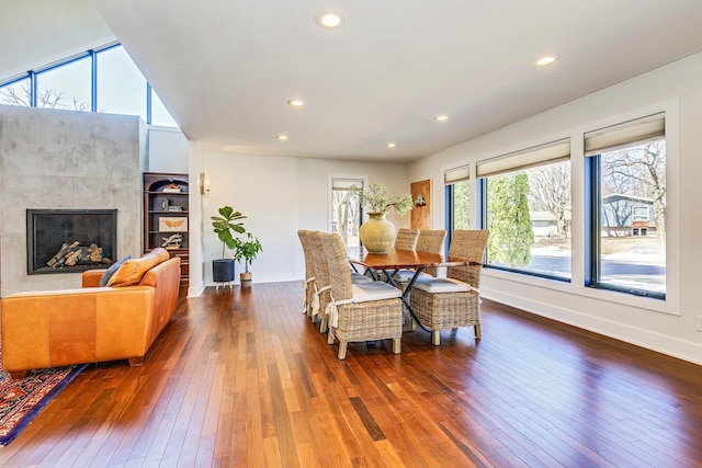 living room featuring recessed lighting, baseboards, dark wood-style floors, and a tile fireplace