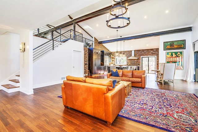 living room featuring high vaulted ceiling, an inviting chandelier, and wood finished floors