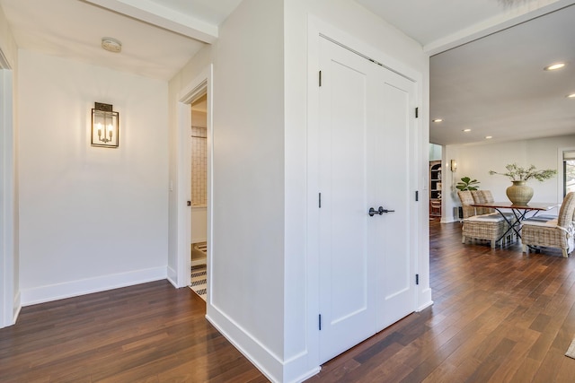 hall featuring dark wood-type flooring, recessed lighting, and baseboards