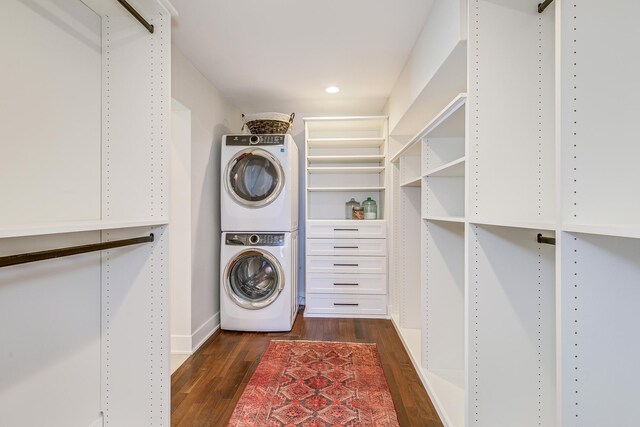 laundry area with laundry area, recessed lighting, stacked washer / drying machine, and dark wood-type flooring