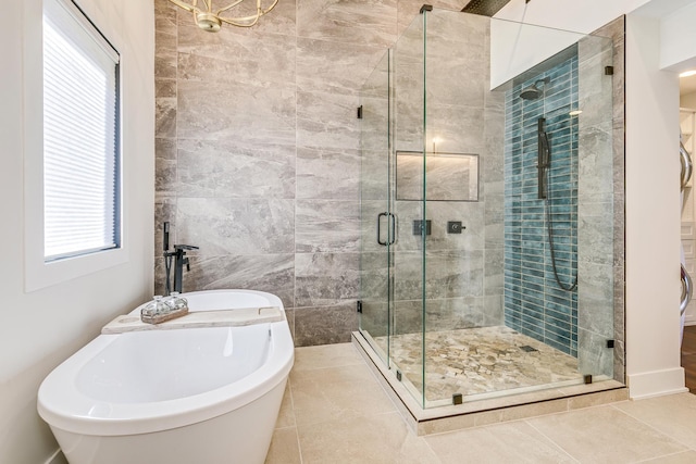 full bathroom with a freestanding tub, a shower stall, and tile patterned flooring