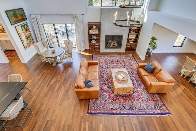 living area featuring wood finished floors, baseboards, and a tile fireplace