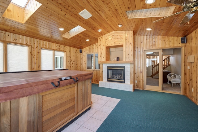 kitchen with butcher block countertops, wood walls, a fireplace, wood ceiling, and lofted ceiling with skylight