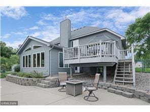 rear view of property with a patio, a chimney, an outdoor fire pit, a deck, and stairs