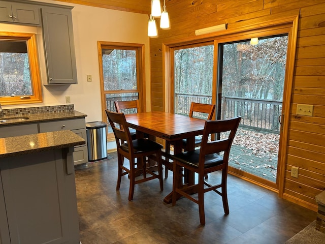 dining space featuring sink and wooden walls