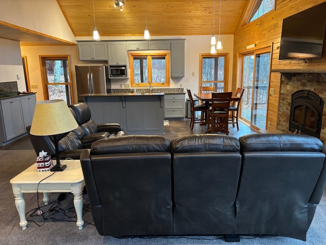 living room with high vaulted ceiling, sink, wooden ceiling, and a fireplace