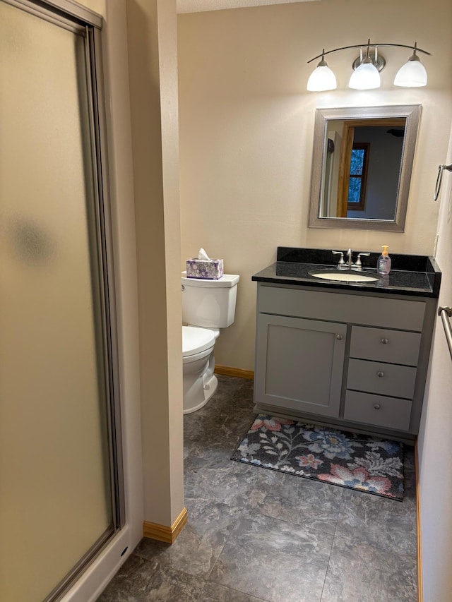 bathroom featuring vanity, toilet, and walk in shower