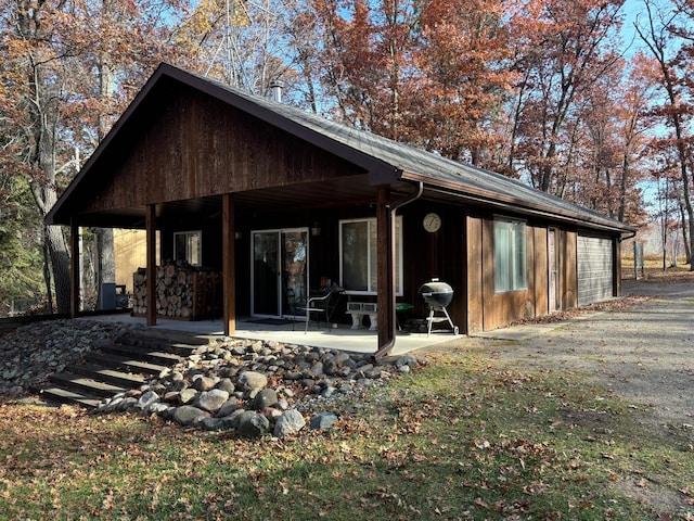 rear view of property featuring a patio area and a garage