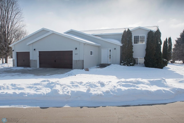 view of front of home featuring an attached garage, stucco siding, and brick siding