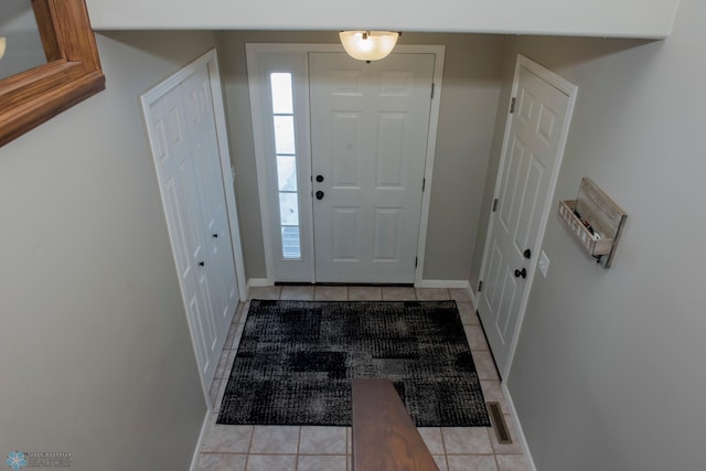 foyer with light tile patterned floors, visible vents, and baseboards