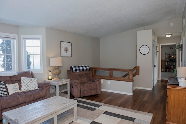 living area featuring baseboards, dark wood finished floors, and a textured ceiling