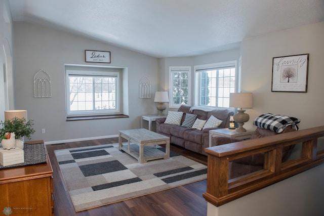 living area featuring vaulted ceiling, dark wood-type flooring, and baseboards