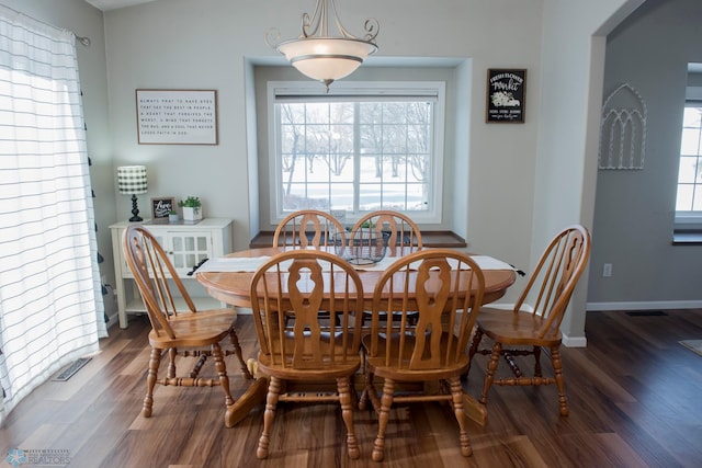 dining space with dark wood-type flooring, visible vents, and baseboards