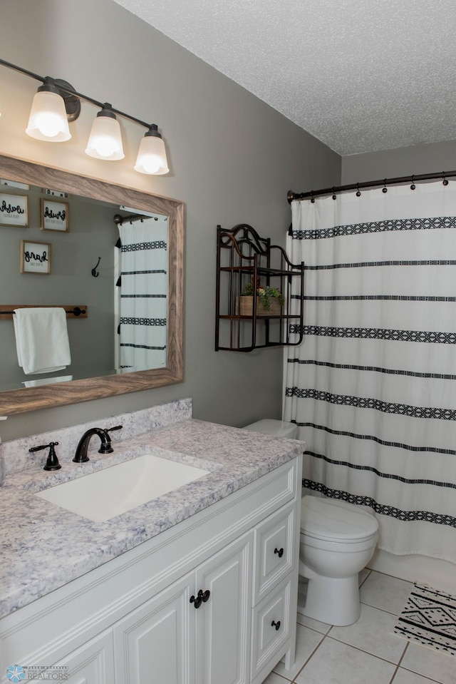 full bathroom featuring toilet, tile patterned flooring, a textured ceiling, and vanity