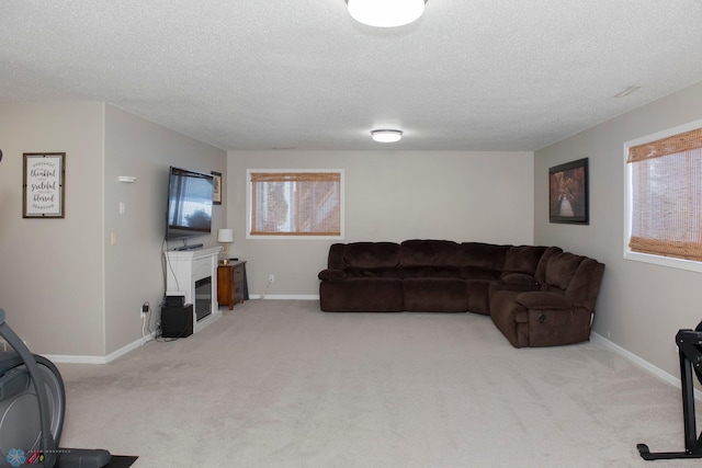 living area with light carpet, a textured ceiling, and baseboards