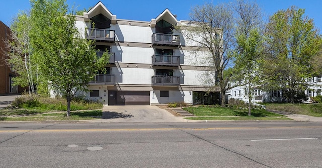 view of apartment building / complex with concrete driveway and an attached garage