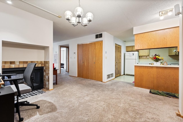 office featuring light colored carpet, a chandelier, and a tiled fireplace
