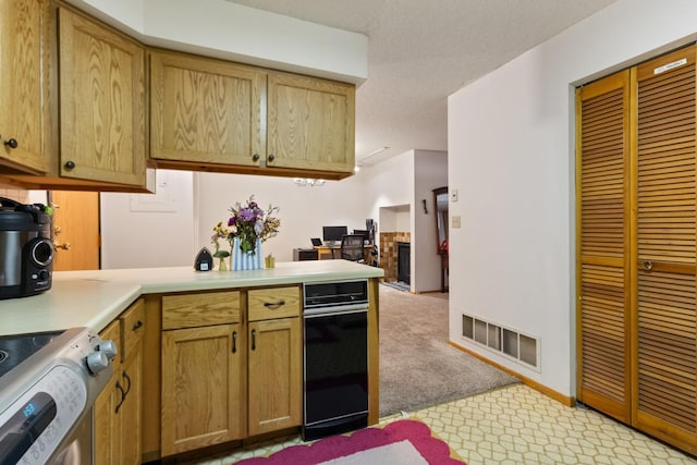 kitchen featuring light countertops, stove, a peninsula, light carpet, and baseboards