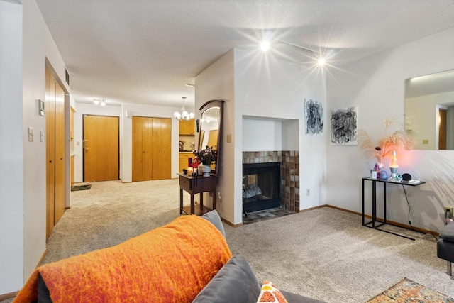 living room with carpet floors, a fireplace with flush hearth, and a chandelier