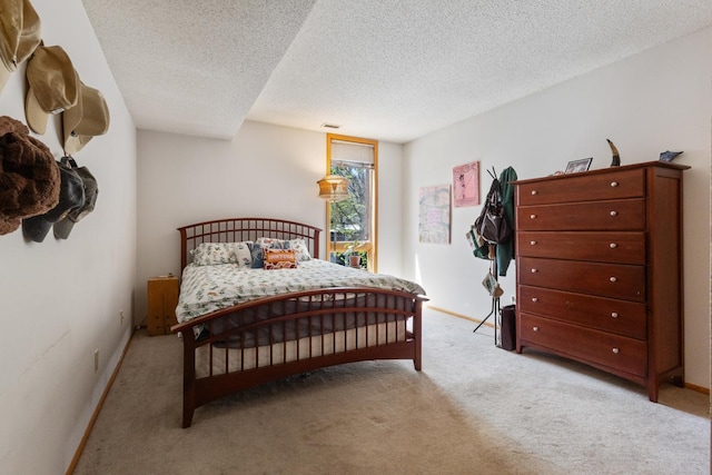 carpeted bedroom with a textured ceiling and baseboards