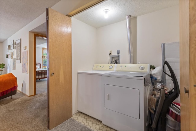 washroom with independent washer and dryer, a textured ceiling, and light carpet