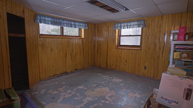 interior space featuring a wealth of natural light, wood walls, and a paneled ceiling