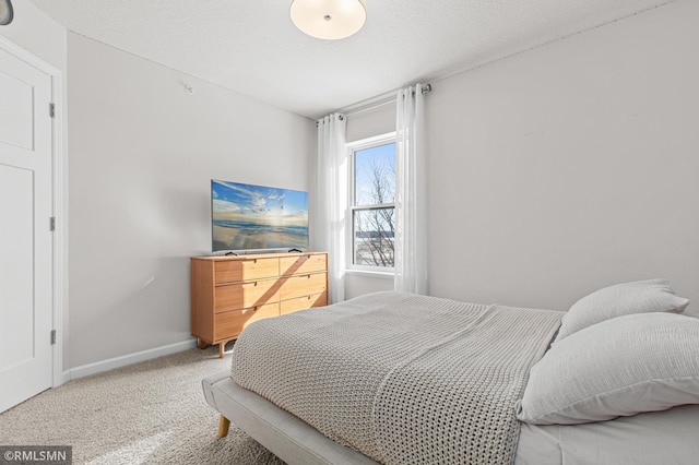 bedroom with carpet floors, a textured ceiling, and baseboards