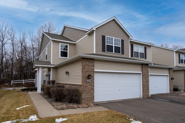 view of front of home with a garage, brick siding, and driveway