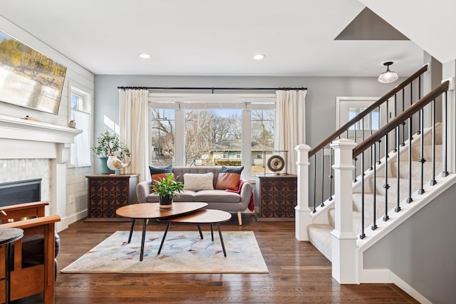 sitting room featuring stairs, baseboards, wood finished floors, and a tile fireplace