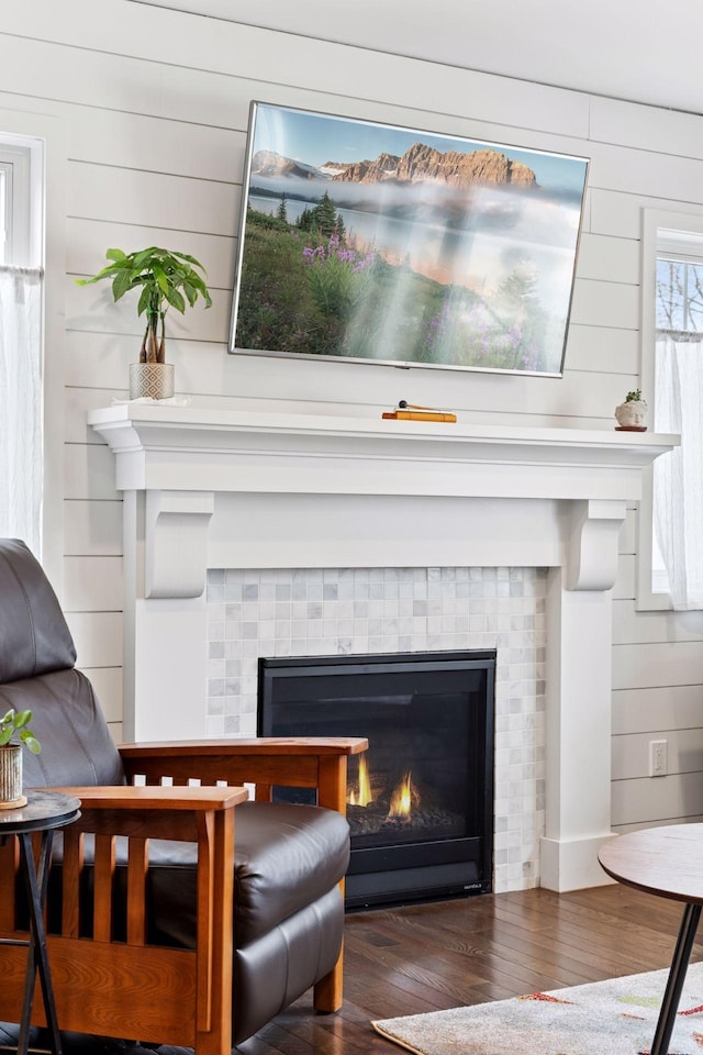 details featuring wooden walls, wood finished floors, and a tile fireplace