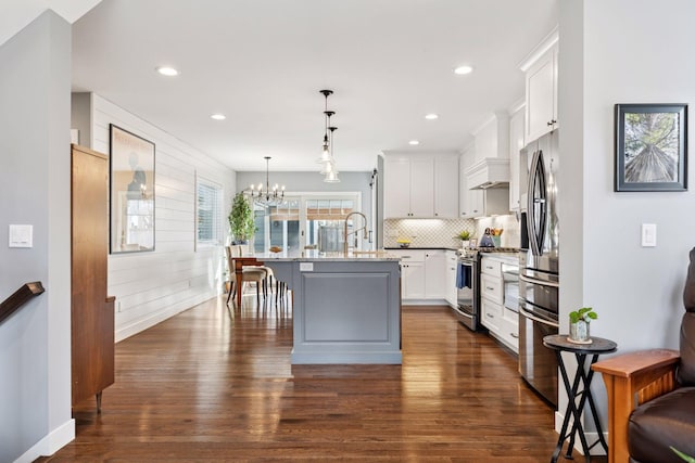 kitchen with appliances with stainless steel finishes, backsplash, dark wood finished floors, and white cabinetry