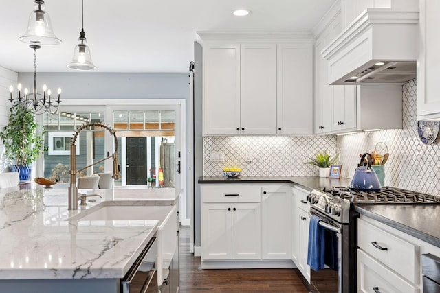 kitchen featuring decorative backsplash, stainless steel range with gas cooktop, white cabinets, and custom range hood