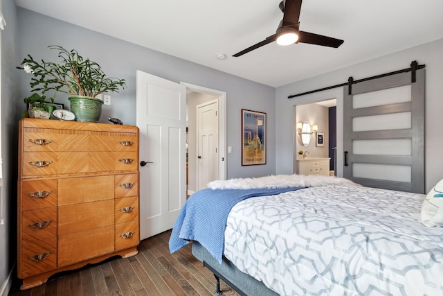 bedroom featuring a barn door, ceiling fan, and dark wood-type flooring