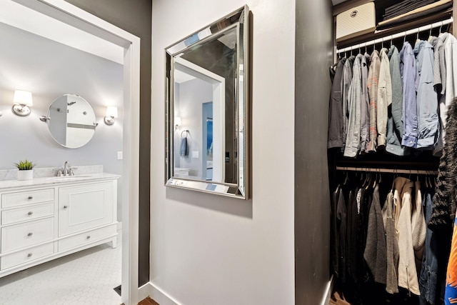 interior space with a spacious closet, vanity, and baseboards