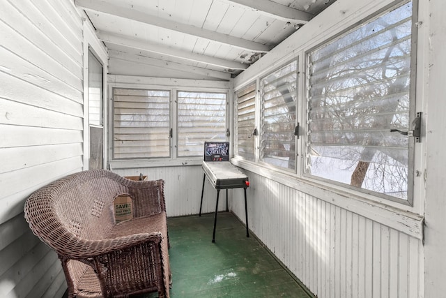 sunroom featuring a wealth of natural light and lofted ceiling with beams