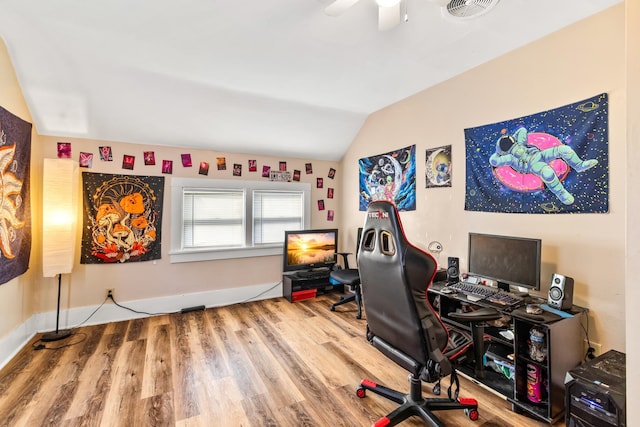 office space with visible vents, vaulted ceiling, baseboards, and wood finished floors