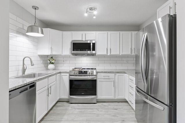 6213 Saint Croix Trl N Unit 102, Oak Park Heights, MN 55082 - kitchen featuring stainless steel appliances, a sink, white cabinetry, and backsplash