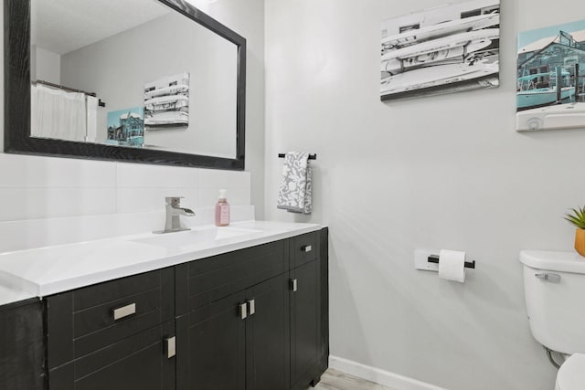6213 Saint Croix Trl N Unit 102, Oak Park Heights, MN 55082 - bathroom featuring backsplash, toilet, and vanity