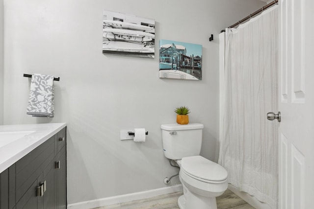 6213 Saint Croix Trl N Unit 102, Oak Park Heights, MN 55082 - bathroom with toilet, vanity, wood finished floors, baseboards, and a shower with shower curtain