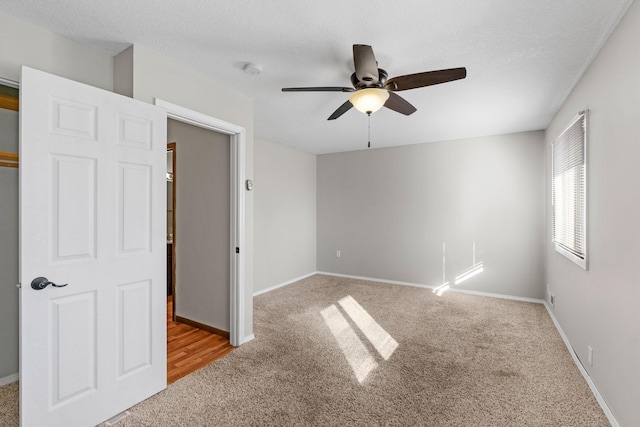 spare room featuring ceiling fan, light carpet, and a textured ceiling