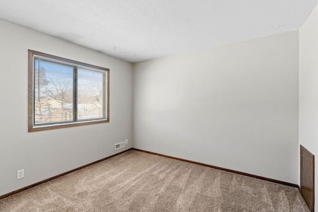 carpeted spare room with a textured ceiling