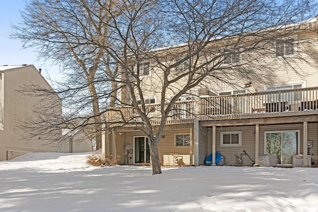 snow covered property with a wooden deck