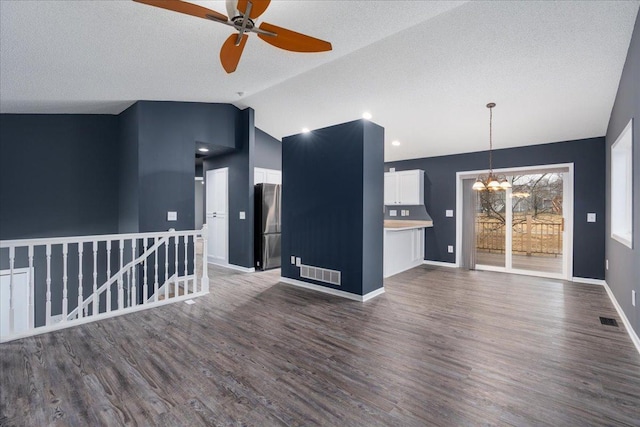 unfurnished living room with lofted ceiling, visible vents, baseboards, and wood finished floors