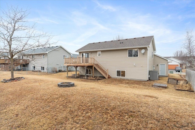 rear view of property featuring an outdoor fire pit, stairs, fence, a deck, and a yard