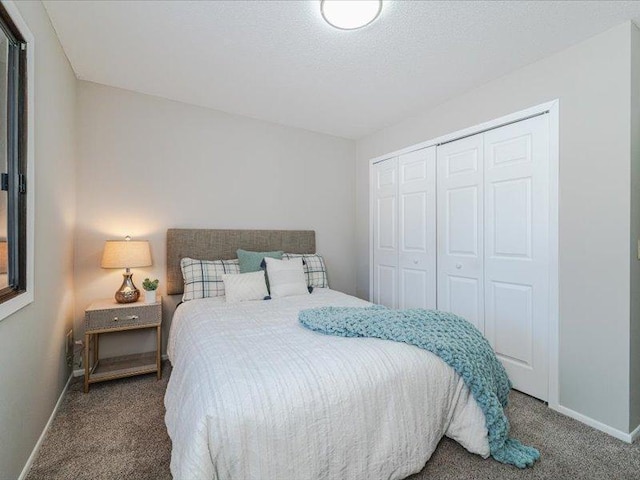 carpeted bedroom with a closet and a textured ceiling