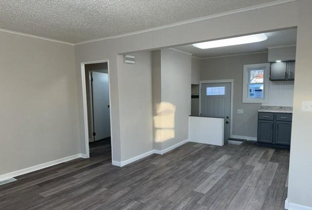 spare room with dark hardwood / wood-style flooring, ornamental molding, and a textured ceiling