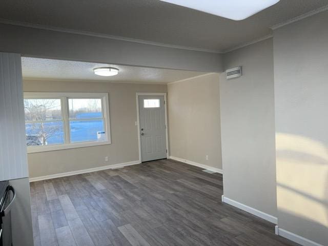 entrance foyer featuring dark wood-type flooring and crown molding