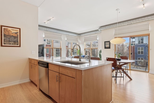 kitchen with a wealth of natural light, light countertops, dishwasher, and a sink